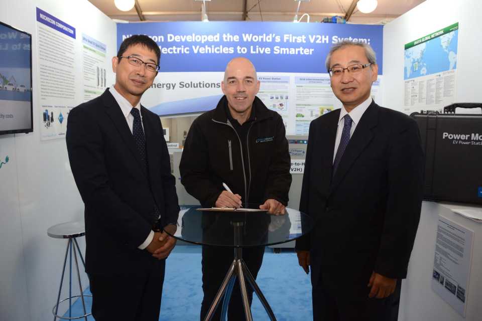 Mike Potter from DriveElectric signing the MOU for V2G chargers with Masahiro Ishiyama, Senior General Manager, and Hiroshi Seki, Business Group Leader, NICHICON CORPORATION, at LCV2017.